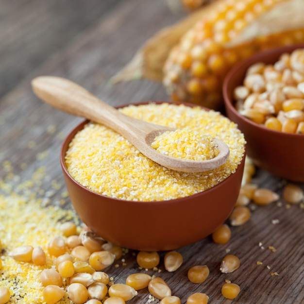 Kasza kukurydziana w misce Nasiona kukurydzy i kolby kukurydzy na kuchennym stole Selektywne skupienie