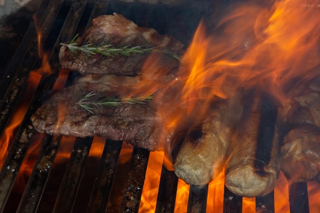 Katastrofalny ogień na grillu z mięsem, pieczywem czosnkowym i kurczakiem