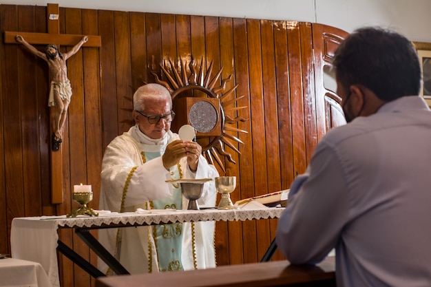 katolicki ksiądz katolicki wygłasza kazania w kościele podczas liturgii w różnych pozach