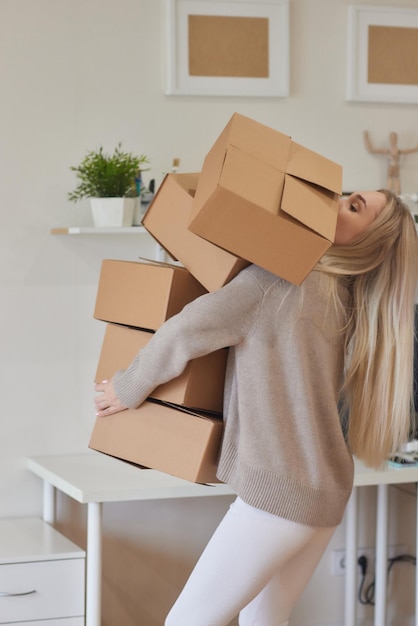 Zdjęcie kaukaska dziewczyna przykleja pudełka do przeprowadzki do nowego mieszkania