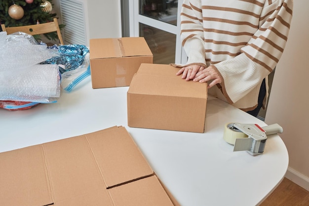 Kaukaska dziewczyna przykleja pudełka do przeprowadzki do nowego mieszkania