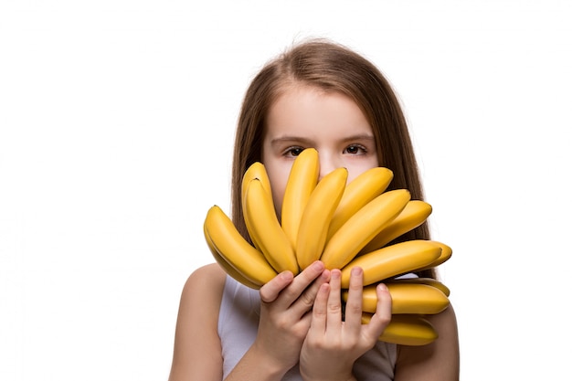 Kaukaska dziewczyna w białych laptopu mienia bananach