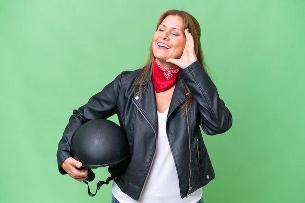 Kaukaska kobieta w średnim wieku z kaskiem motocyklowym na odizolowanym tle, bardzo się uśmiecha
