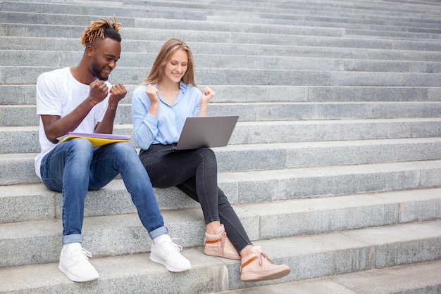 Kaukaska kobieta z Afroamerykaninami Międzynarodowi studenci siedzący na schodach w parku