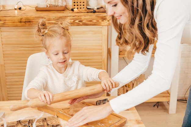 Kaukaska mama i córki przygotowują świąteczne ciasteczka w kuchni