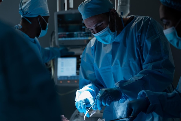 Kaukaski chirurg płci męskiej noszący maskę i odzież ochronną podczas operacji w szpitalu