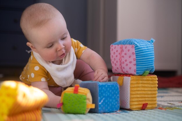 Kaukaski maluch bawi się samotnie w kolorowe klocki