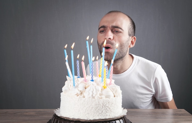 Kaukaski mężczyzna dmuchanie świeczki urodzinowe.