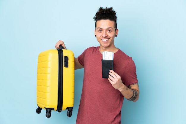 Kaukaski mężczyzna na białym tle niebieski w wakacje z walizką i paszportem