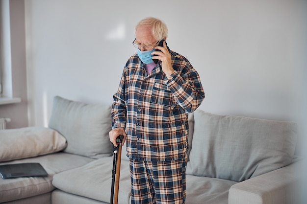 Kaukaski mężczyzna na emeryturze rozmawia przez smartfon