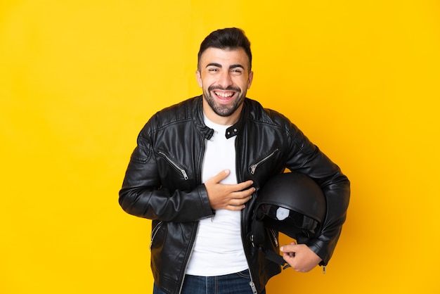 Kaukaski mężczyzna w kasku motocyklowym na pojedyncze żółte uśmiechnięte dużo