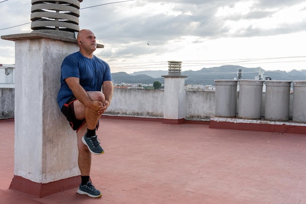 Kaukaski mężczyzna w średnim wieku ćwiczy i uprawia sport na tarasie budynku