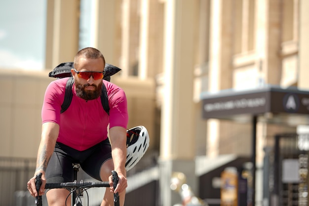 Kaukaski przystojny młody mężczyzna w kasku ochronnym wychodzi na przejażdżkę rowerową ulicami miasta na niewyraźne tło Rowerzysta mężczyzna jeździć na rowerze na zewnątrz w mieście