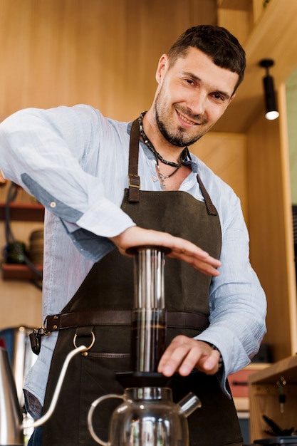 Kawa Aeropress: barista prasa do urządzenia, a krople kawy wylewają się przez aeropress do garnka