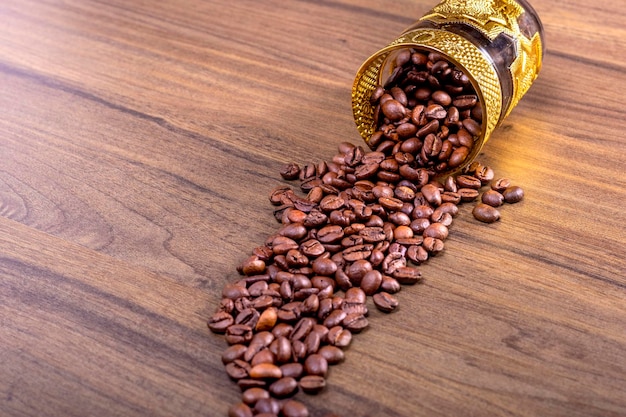 Kawa Arabika Kubek ze szkła mauretańskiego leżący na drewnianej podłodze z naturalnymi ziarnami kawy Koncepcja Międzynarodowego Dnia Kawy 1 października
