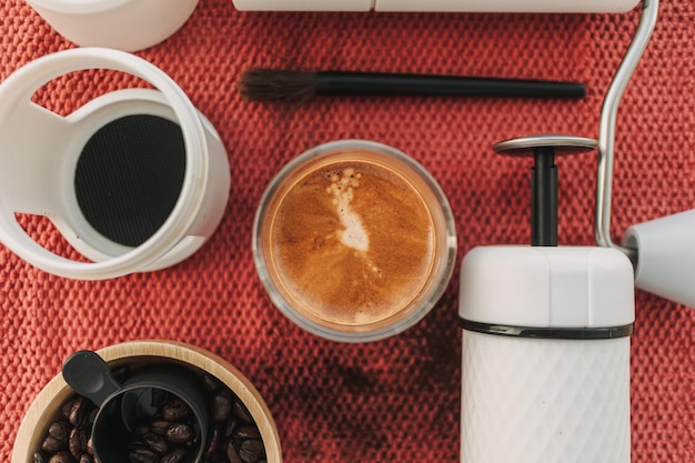 Kawa espresso z ekspresem do kawy i urządzeniami do mielenia na czerwonym płótnie
