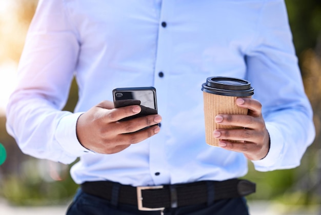 Kawa i przerwa na social media. Ujęcie nierozpoznawalnego biznesmena za pomocą telefonu podczas picia kawy na zewnątrz.