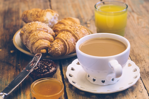 Kawa i rogaliki z dżemem i sokiem pomarańczowym. Typowe francuskie śniadanie (Petit Déjeuner)