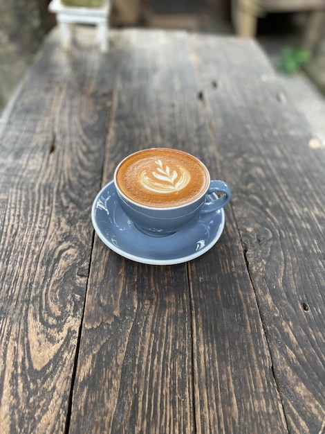 Kawa Latte Art na drewnianym stole w kawiarni.