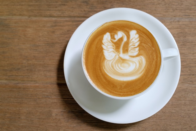 kawa latte art na tle drewna