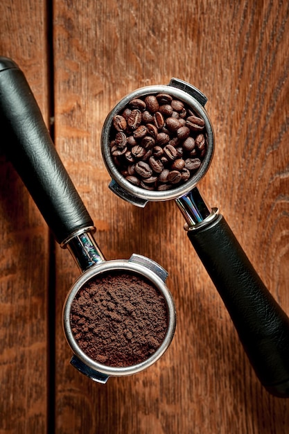 Kawa mielona i ziarna w uchwycie z ekspresu do kawy na drewnianym tle Koncepcja kawy