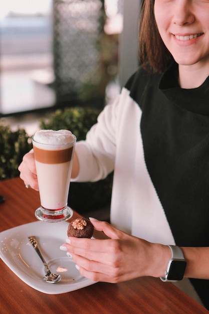 Kawa mrożona z mlekiem. Mrożona kawa latte . Kobieta trzyma szklany kubek mrożonej kawy.