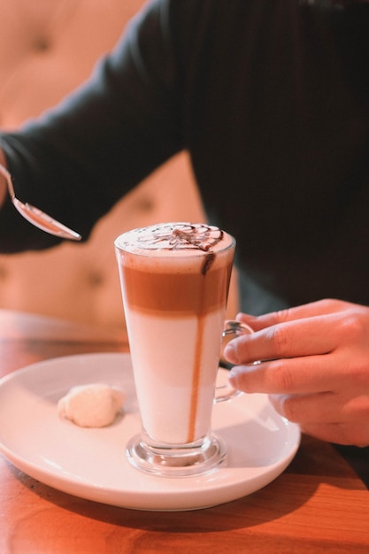 Kawa mrożona z mlekiem. Mrożona kawa latte . Kobieta trzyma szklany kubek mrożonej kawy.