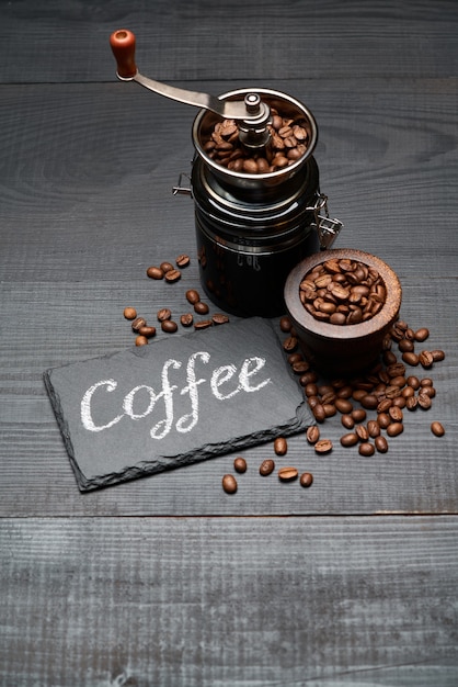 Kawa odręczny napis znak na tablicy kredowej młynek do kawy i fasola na ciemnym drewnianym stole