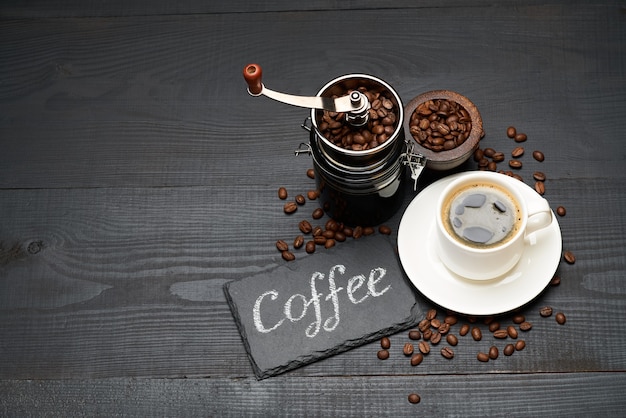 Kawa odręczny napis znak na tablicy kredowej młynek do kawy i filiżanka espresso na ciemnym drewnianym stole