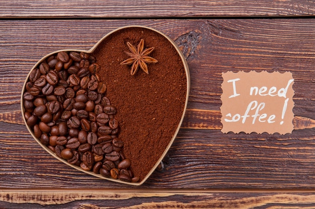Kawa pełnoziarnista i rozpuszczalna zaaranżowana w kształcie serca. Jedna z jedną częścią wypełnioną ziarnami kawy, a drugą z kawą rozpuszczalną. Potrzebuję kawy.