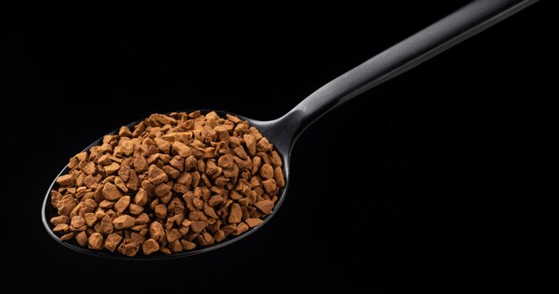 Kawa rozpuszczalna granulowana w łyżkę na czarnym tle
