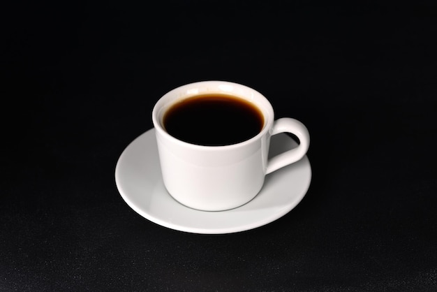 Zdjęcie kawa w białych naczyniach na ciemnym tle.