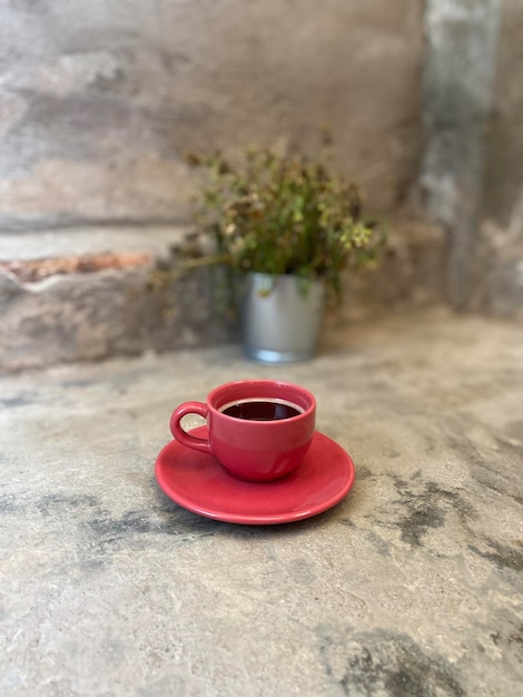 Kawa w czerwonej filiżance na cementowej podłodze w kawiarni