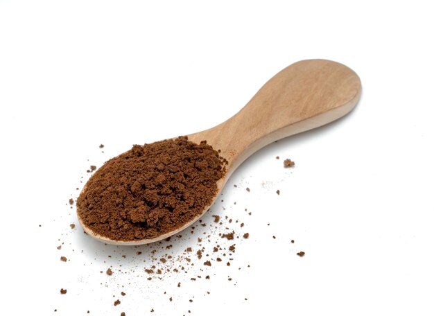 Kawa w proszku z drewnianą łyżką izolowaną na białym tle