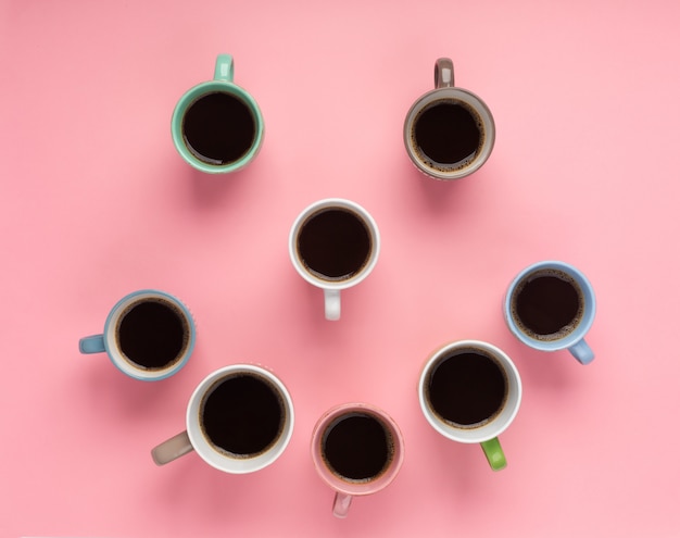 Kawa w różnych filiżankach na różowym tle. Flatlay, koncepcja wesoły dzień