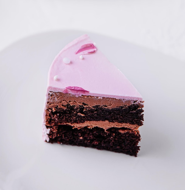 Kawałek ciasta czekoladowego z różową śmietaną