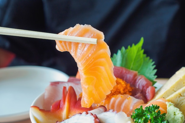 Kawałek łososia pałeczkami, miska ryżu Sashimi Chirashi Don Japońskie jedzenie