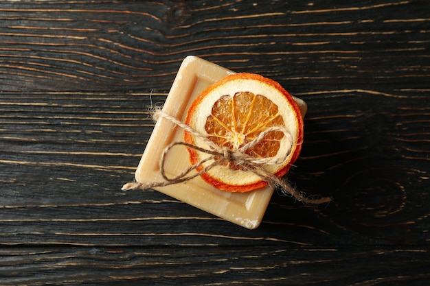 Kawałek naturalnego pomarańczowego mydła na podłoże drewniane