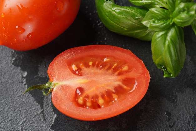 Kawałek pokrojonego świeżego pomidora na ciemnym tle