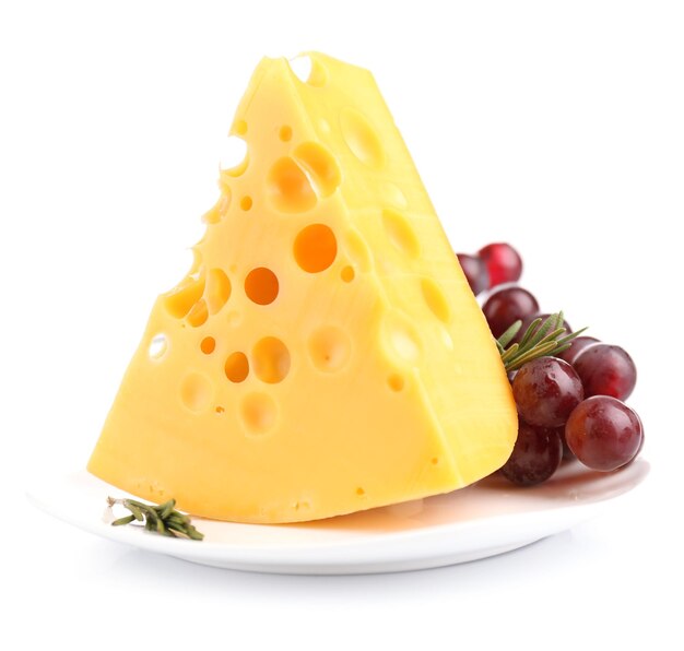 Kawałek sera z winogronami i rozmarynem na talerzu na białym tle