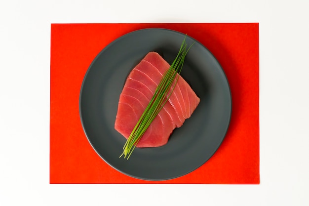 Zdjęcie kawałek surowego tuńczyka z szczypiorkiem