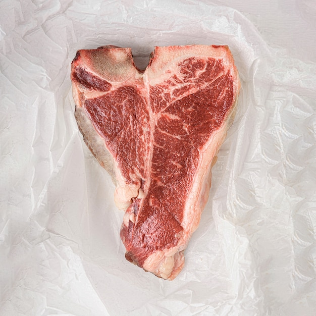 kawałek świeżego mięsa z farmy t-bon niemodyfikowany genetycznie, owinięty ekologicznym papierem pakowym