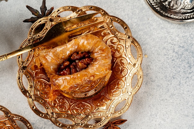 Kawałek tureckiej baklawy w złotej płycie arabskiej z bliska