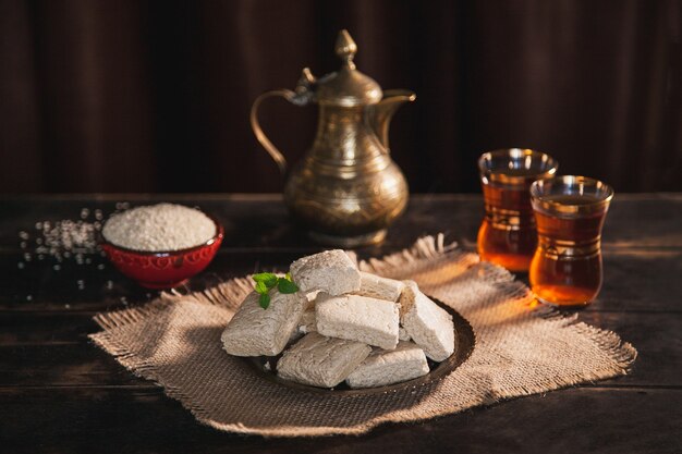 kawałki chałwy tahini, sezam w misce, herbata w tureckiej armudas vintage dzbanek
