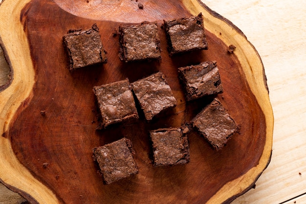 Kawałki ciasta brownie na drewnianej desce do krojenia