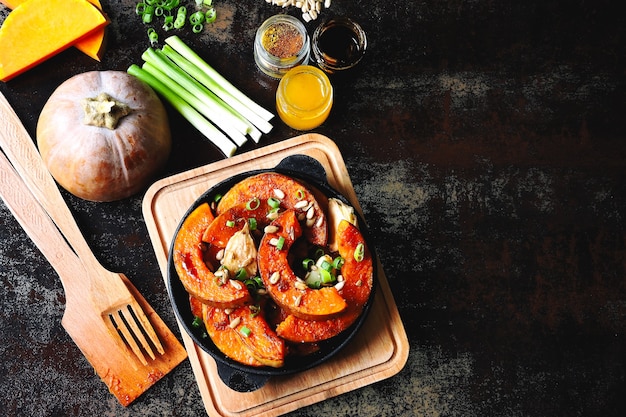 Kawałki Dyni Zapiekane Na Małej Patelni Z Zieleniną I Nasionami. Upieczona Dynia. Wegański Lunch Z Pikantną Pieczoną Dynią. Przydatna Jesienna Przekąska. Obiad Halloween