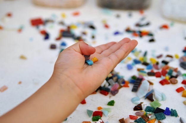 Kawałki Kolorowej Mozaiki Szklanej W Dłoni Dziecka Na Stole