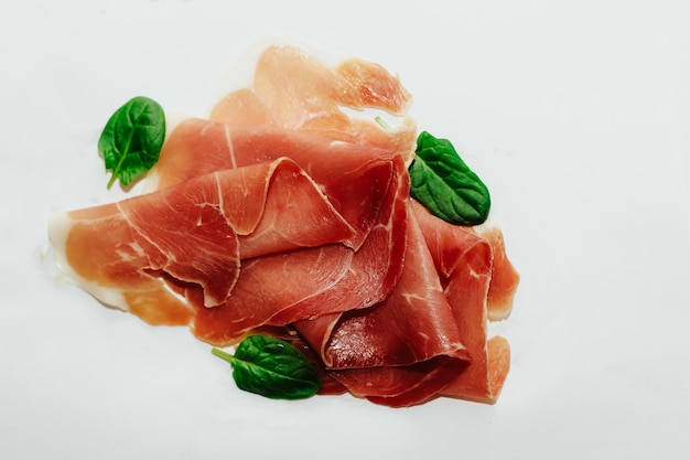 Kawałki suszonej wieprzowiny jamon prosciutto na białym tle