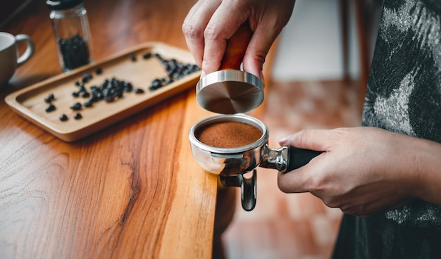 Kawiarnia Barista robiąca kawę za pomocą ręcznych pras mielona kawa za pomocą ubijaka na drewnie