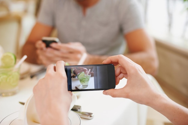 Zdjęcie kawiarnia zdjęcie i para z ekranem telefonu komórkowego i połączenie z walentynkami dzień i fotografia data mężczyzna i kobieta ze smartfonem i aplikacją cyfrową dla pamięci i romansu z restauracji lub luksusu